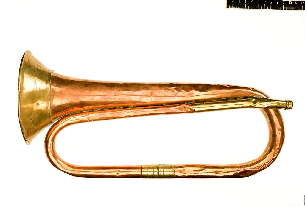 F76 Signalhorn - An old brass trumpet sitting on top of a white