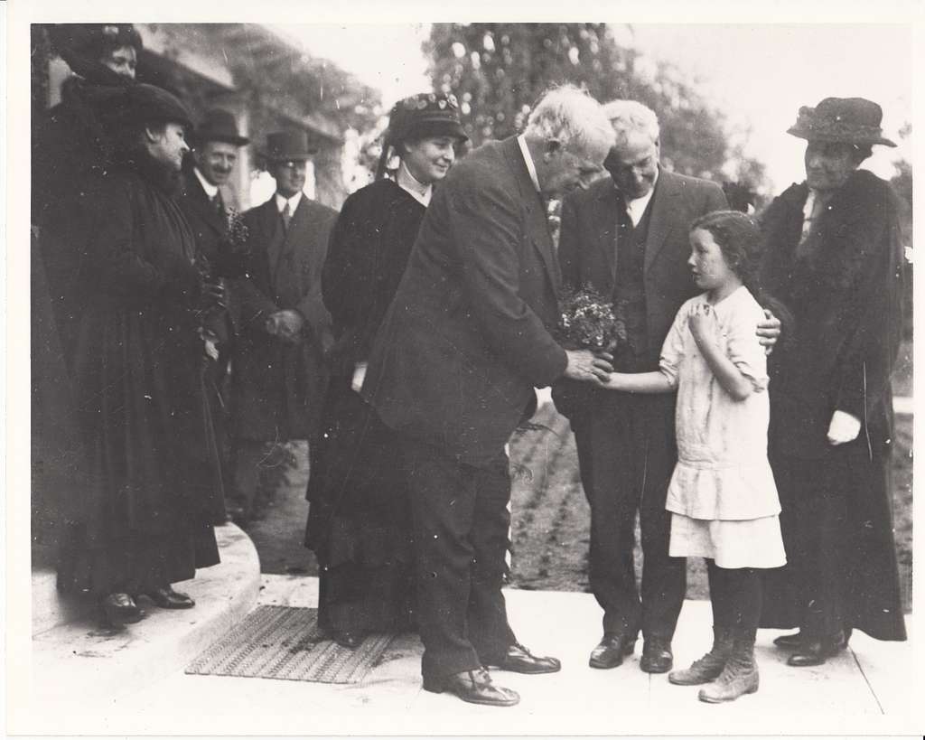 Thomas Edison being given flowers by a young girl on California trip. Mina  Edison is standing just behind Edison. - PICRYL - Public Domain Media  Search Engine Public Domain Image