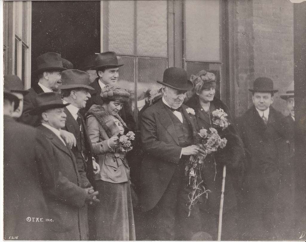 Thomas Edison, family members, and others holding flowers in doorway of ...