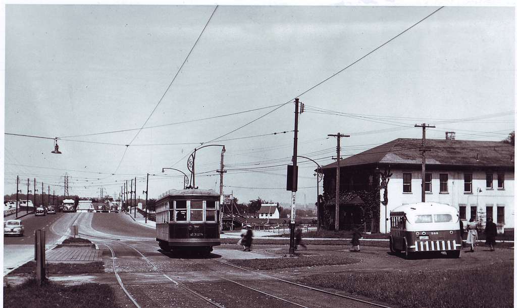 In the distance a MIMICO bus approaches old Humber Loop while another (TTC  bus 588) pauses in the loop and a Long Branch streetcar (Witt 2328) departs  - PICRYL - Public Domain