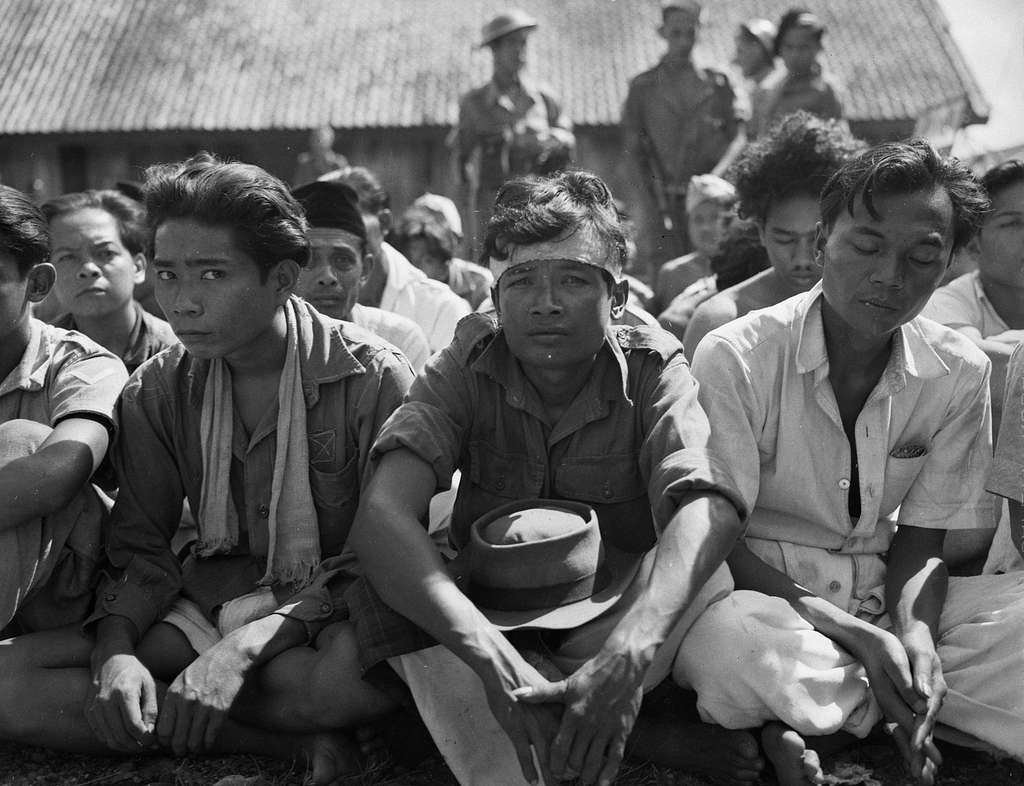 Indonesische krijgsgevangen of arrestanten zitten in lotuszit op de ...