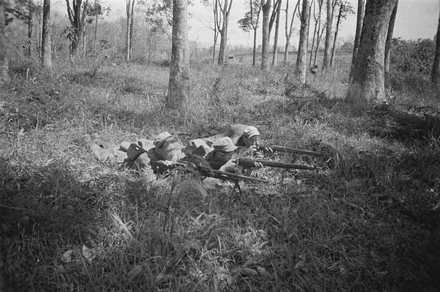 Patrouille. Drie soldaten liggend op de rond, geweren en lichte ...