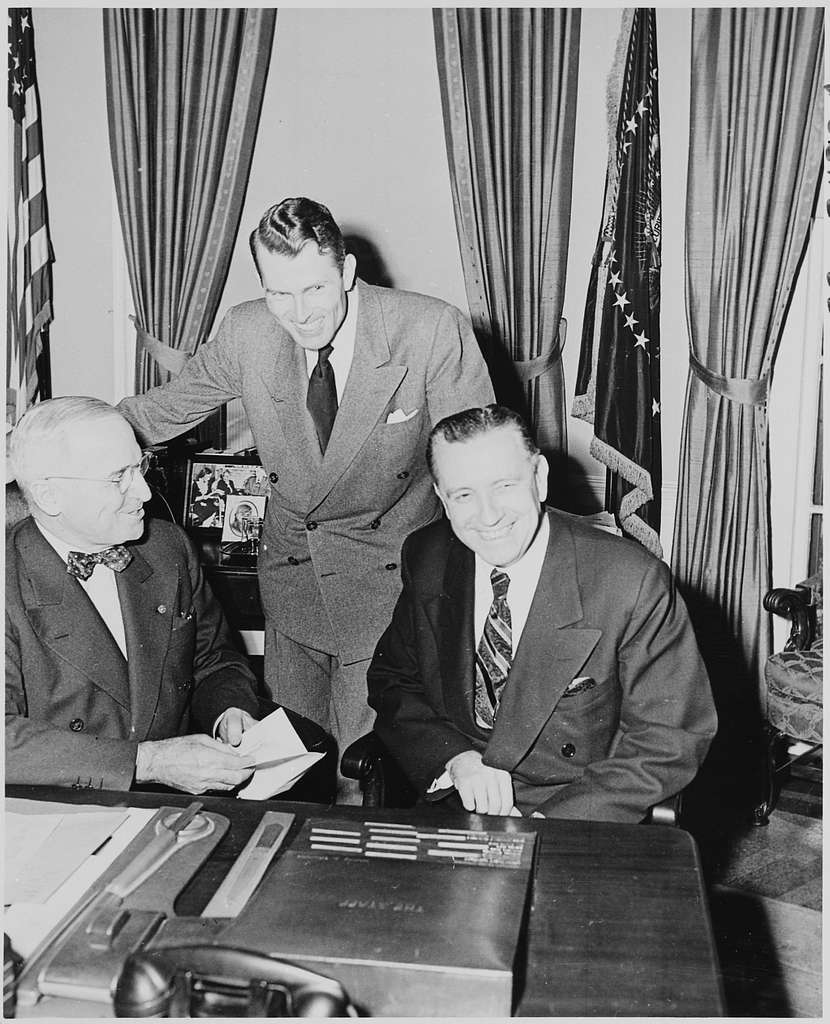 Photograph of President Truman at his desk in the Oval Office with ...