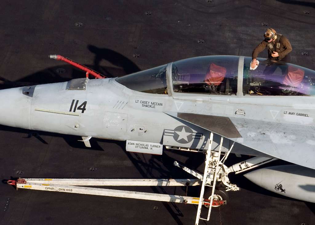 A plane captain cleans the canopy of an F/A-18 aboard - NARA & DVIDS ...