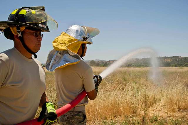 A U.S. Air Force firefighter pulls a fire hose into - PICRYL - Public  Domain Media Search Engine Public Domain Search