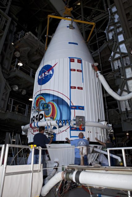 Technicians install lockers on the middeck of space shuttle Atlantis as ...