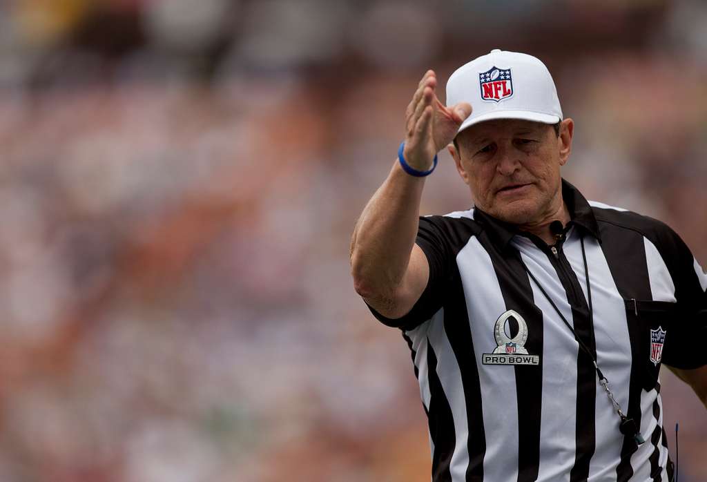 Portrait of NFL referee Ed Hochuli gesturing the personal foul