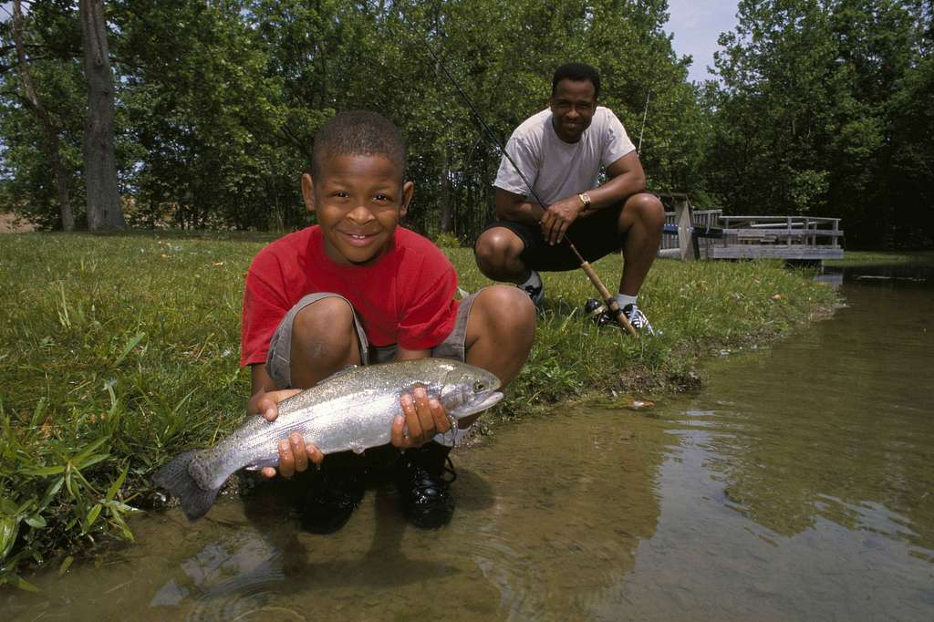 A father and son get their picture taken with fish in hand