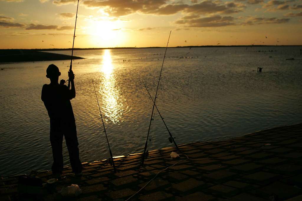 Young man stands fishing at sunset - PICRYL - Public Domain Media Search  Engine Public Domain Search