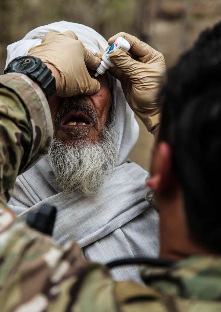 A coalition forces member administers eye drops to - PICRYL