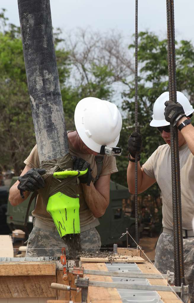 U.S. Army Spc. Josh Thomas left pours concrete in NARA DVIDS