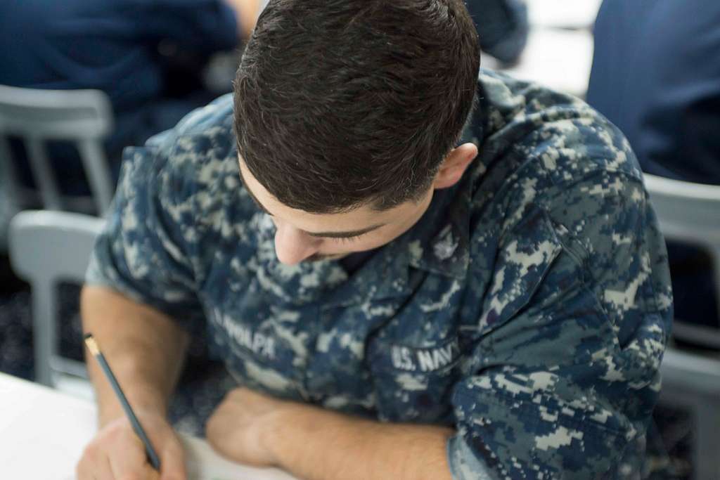 Offensive Tackle for the National Football League (NFL) San Diego Chargers,  Leander Jordan (75), signs an autograph for Aviation Electrician's Mate 3rd  Class Jerimy Holt during a visit aboard USS Ronald Reagan (