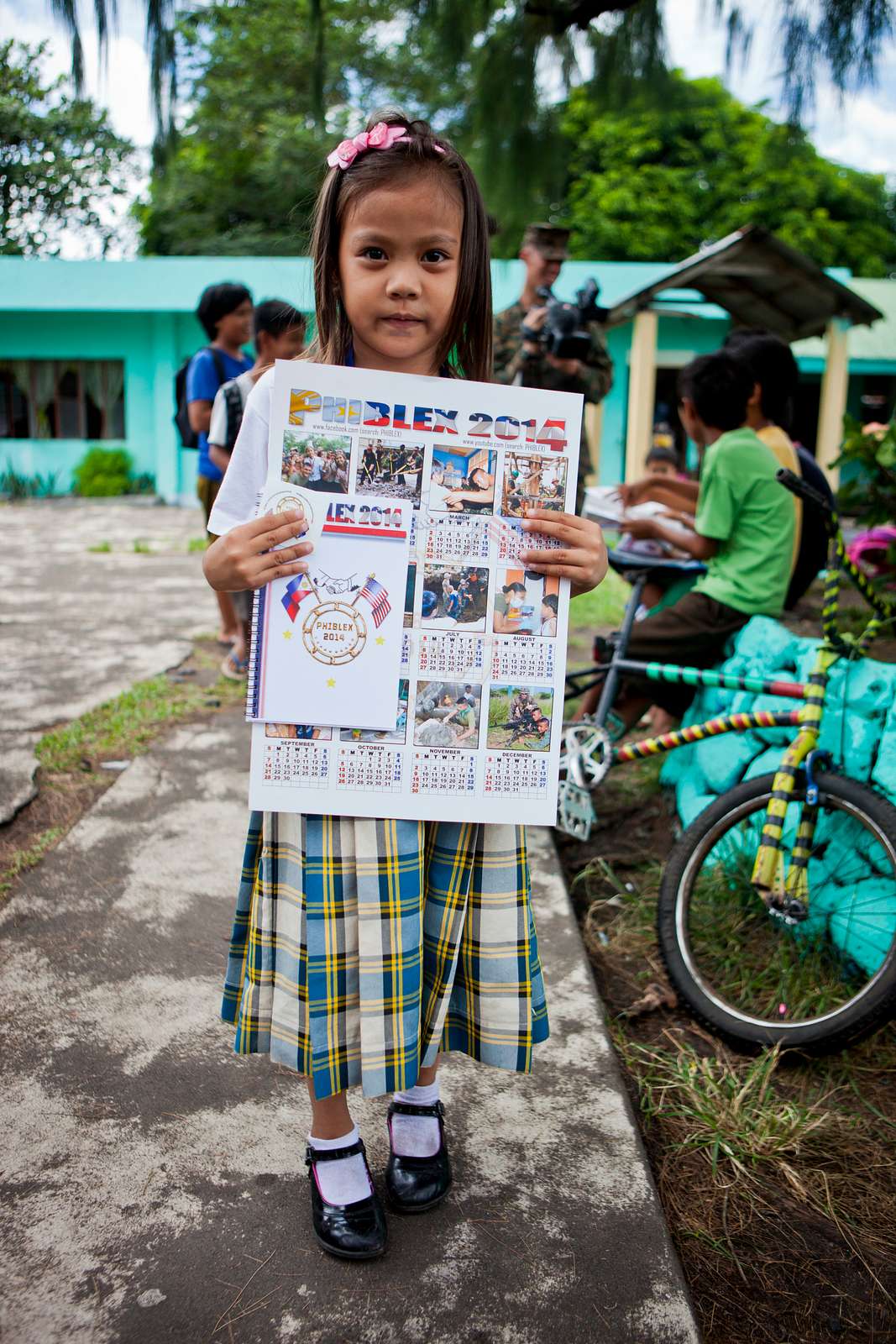 A Filipino girl shows off a calendar she received from NARA & DVIDS