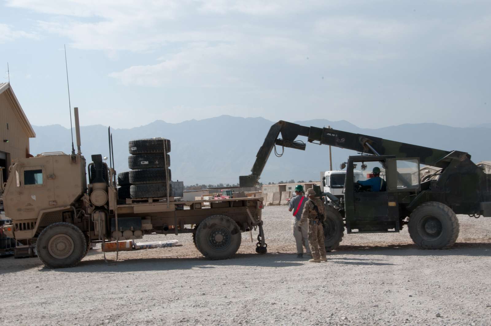 A forklift operator loads tires on a light medium tactical - NARA ...