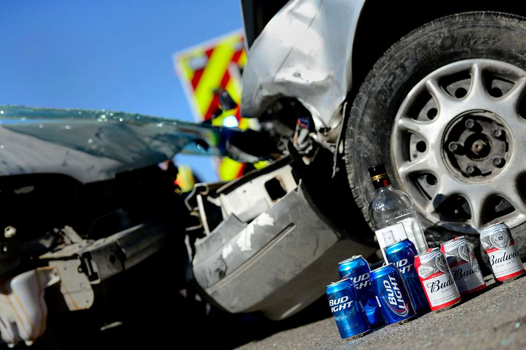 Liquor bottles lifting a car crash with road signs. This