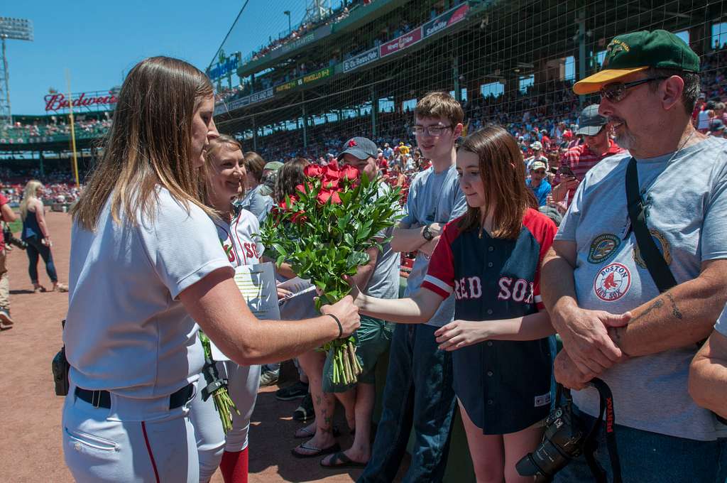 A Boston Red Sox ball girl hands roses to Molly McLaughlin