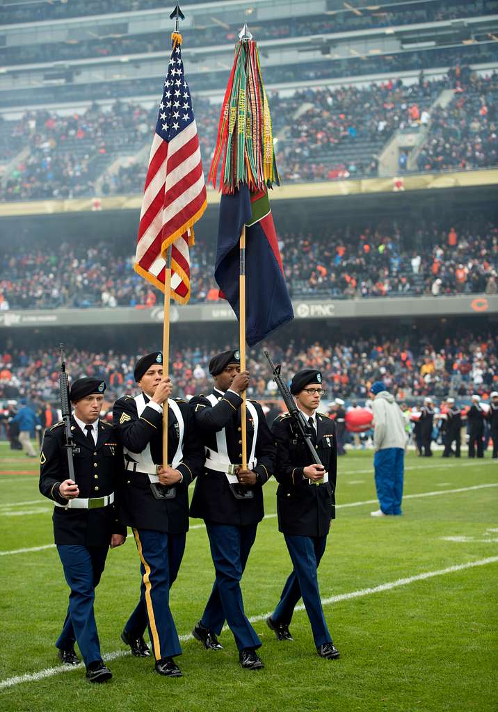 Illinois Army National Guard 2nd Lt. Zachary White, of Chicago, takes a  photo with Staley Da Bear, the Chicago Bears mascot during the Chicago Bears  Salute to Service game Nov. 27 at