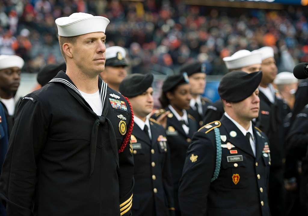 Illinois Army National Guard 2nd Lt. Zachary White, of Chicago, takes a  photo with Staley Da Bear, the Chicago Bears mascot during the Chicago Bears  Salute to Service game Nov. 27 at