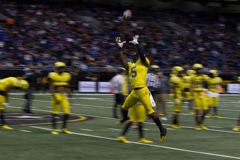 Darnay Holmes, defensive back for the West team, leaps - PICRYL