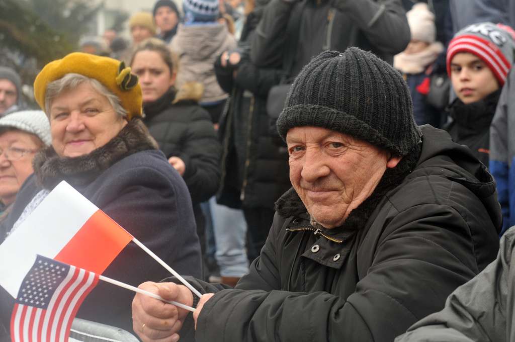 A local citizen holds an American and Polish flag during - PICRYL