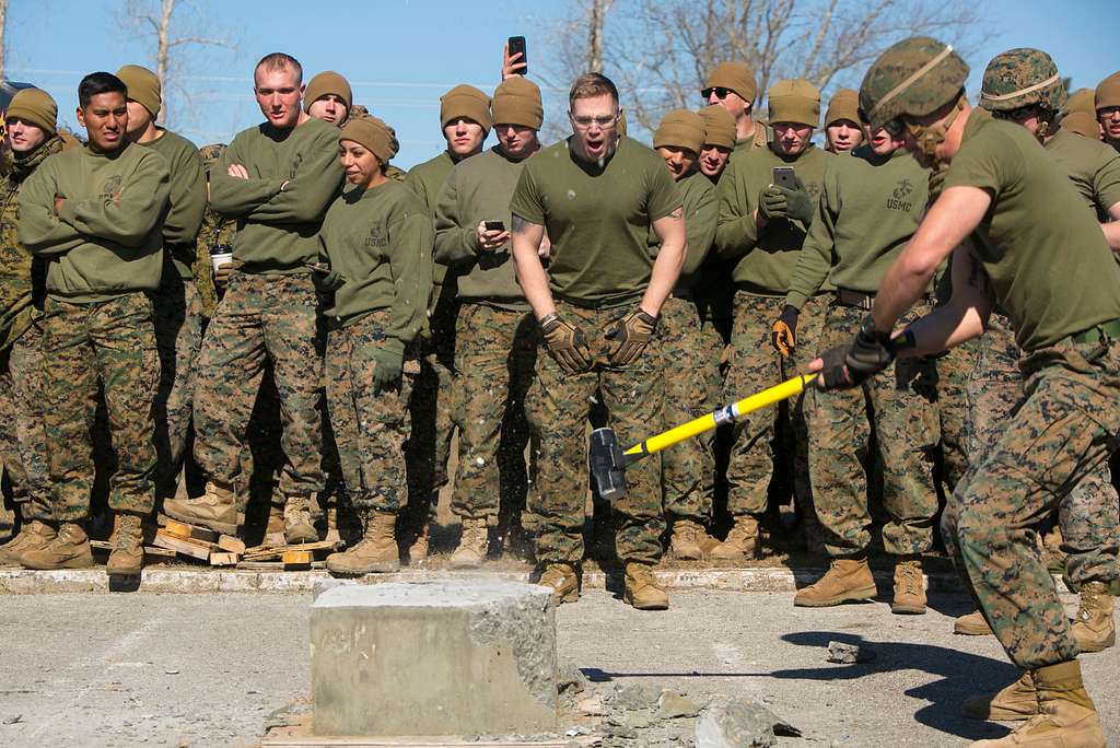 A Marine uses a sledgehammer to break a slab of concrete - PICRYL