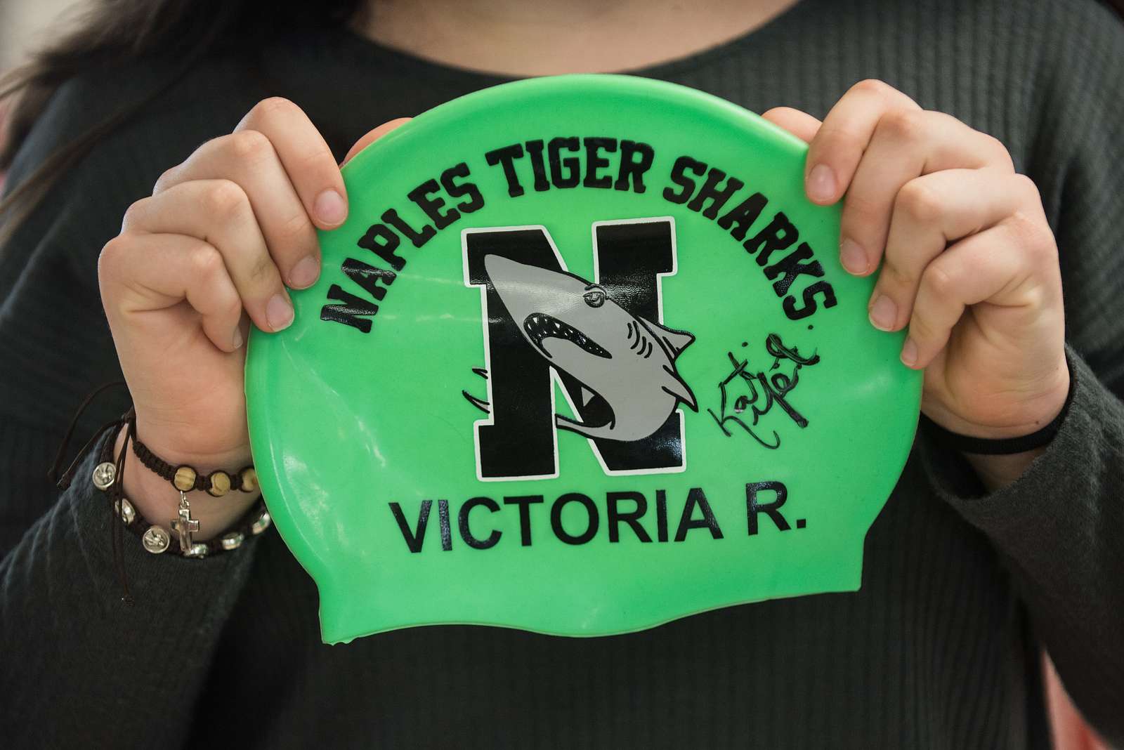 a-child-holds-a-swim-cap-signed-by-u-s-olympic-swimmer-nara-dvids