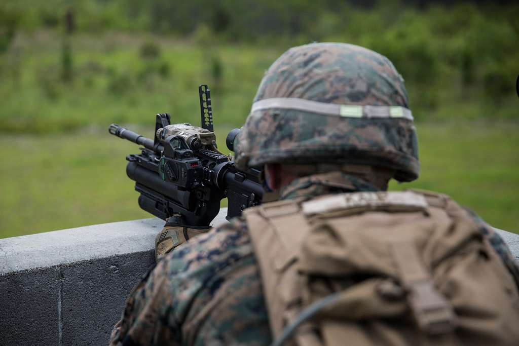 A Marine observes a target through a sight on an M320 - PICRYL Public ...