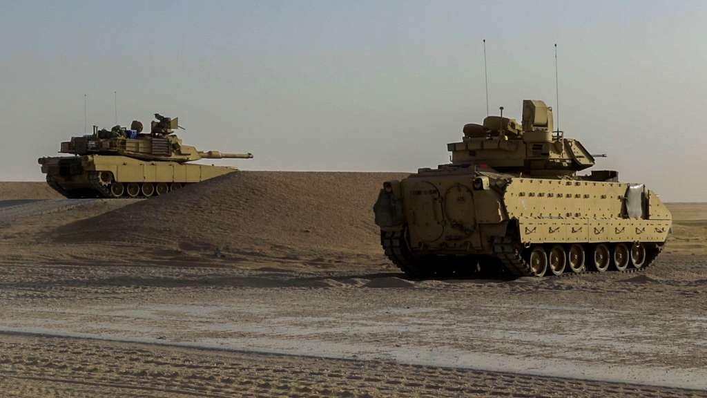 An M1A2 Abrams tank (left) prepares to fire a round - NARA & DVIDS ...