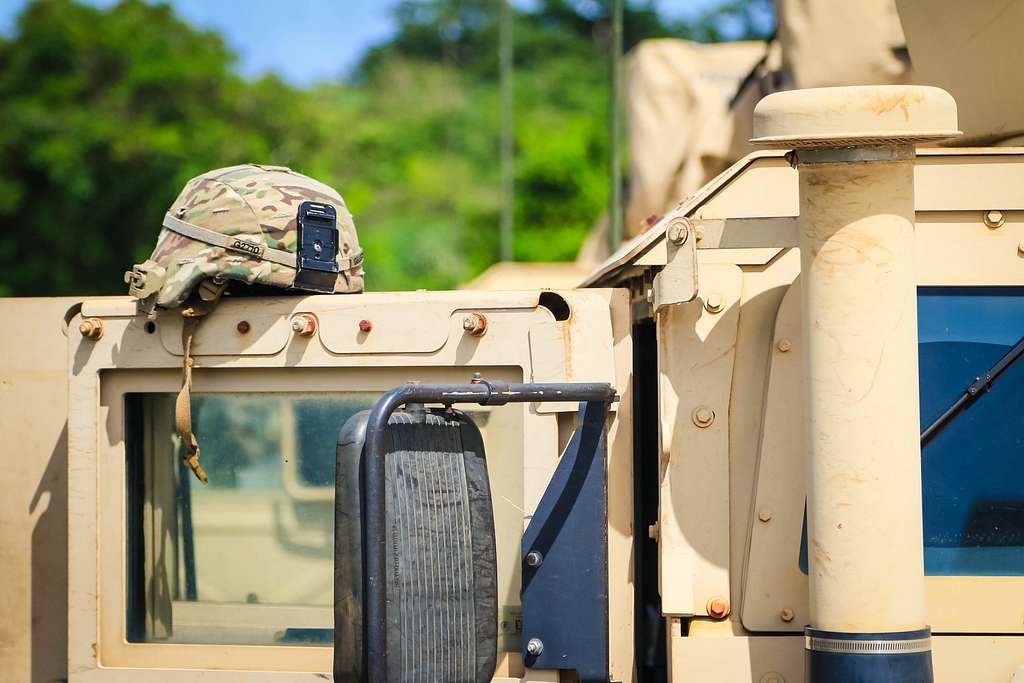 A military kevlar sits on the door of a military Humvees - PICRYL