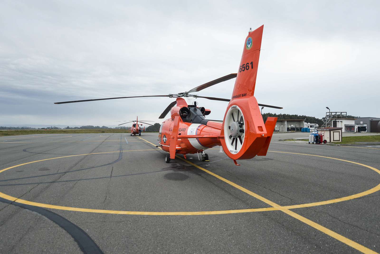 An MH-65 Dolphin helicopter is shown on the tarmac - NARA & DVIDS ...