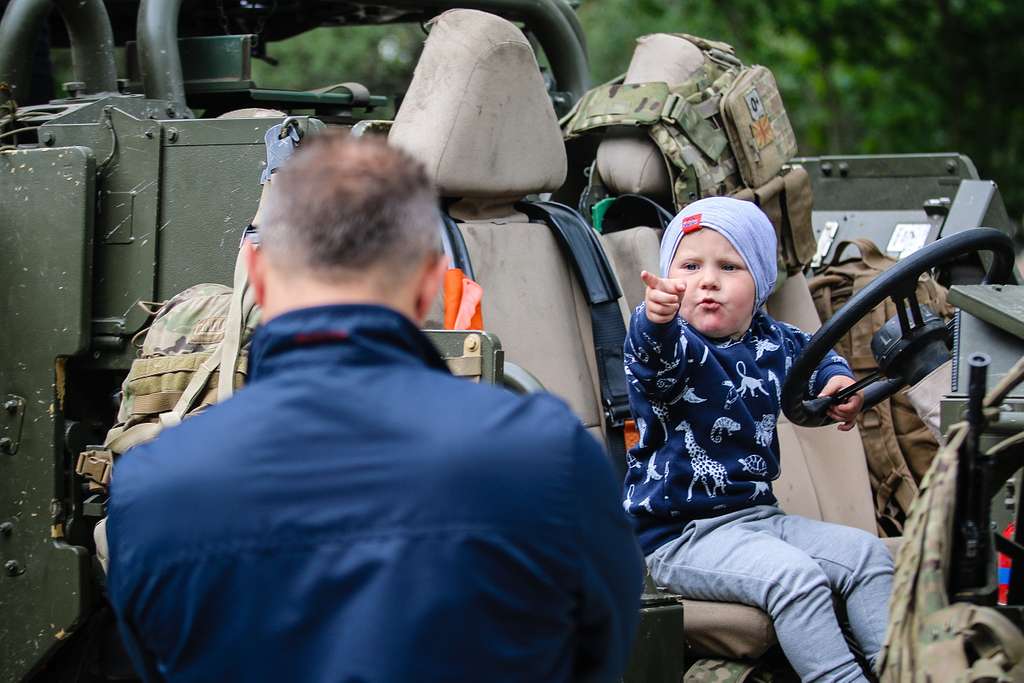 A Polish child points at his father while siting in - NARA & DVIDS ...