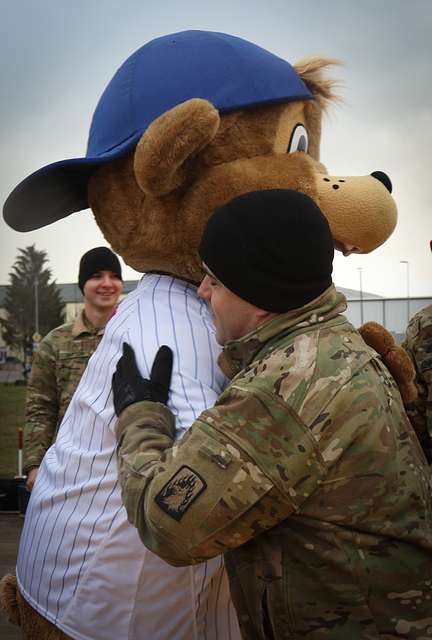 A U.S. Army Soldier's son poses with Clark, the Chicago Cubs mascot, at the  USO at USAG Bavaria in Grafenwoehr, Germany, Dec. 11, 2018. The USO  sponsored a Chicago Cubs mascot tour