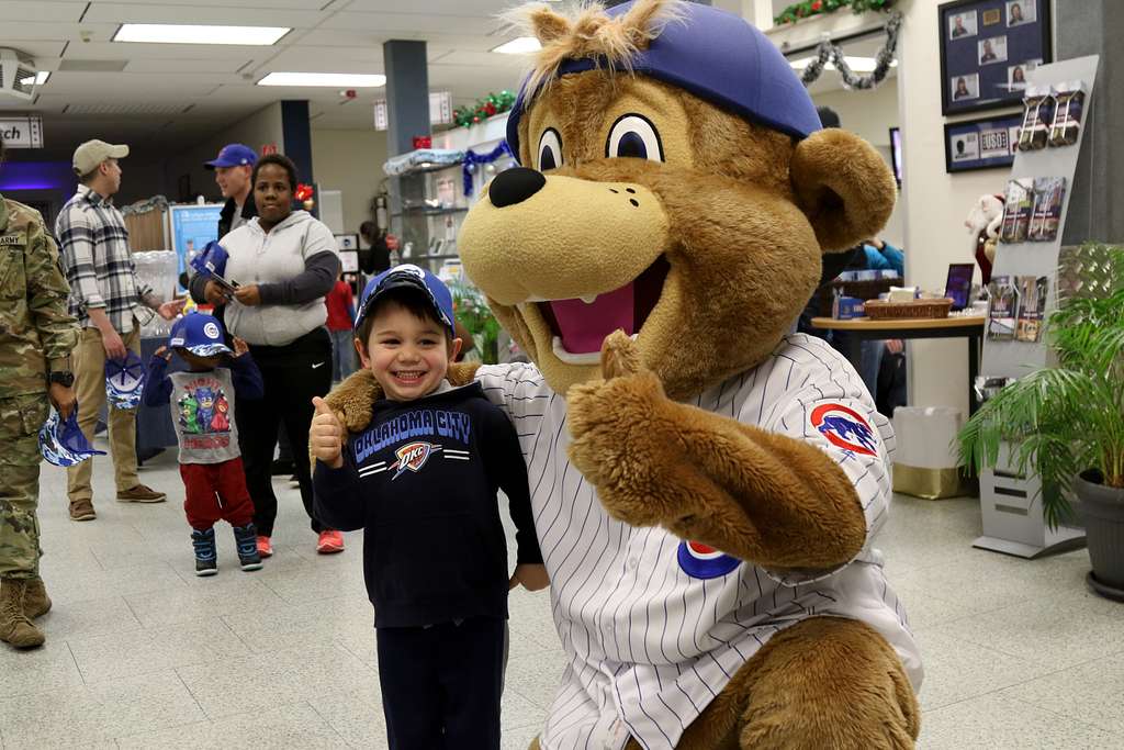 Clark, the Chicago Cubs mascot, signs a hat for a fan at the USO at USAG  Bavaria in Grafenwoehr, Germany, Dec. 11, 2018. The USO sponsored a Chicago  Cubs mascot tour of