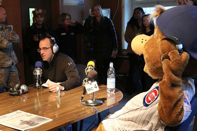 Clark, the Chicago Cubs mascot, signs a hat for a fan at the USO at USAG  Bavaria in Grafenwoehr, Germany, Dec. 11, 2018. The USO sponsored a Chicago  Cubs mascot tour of