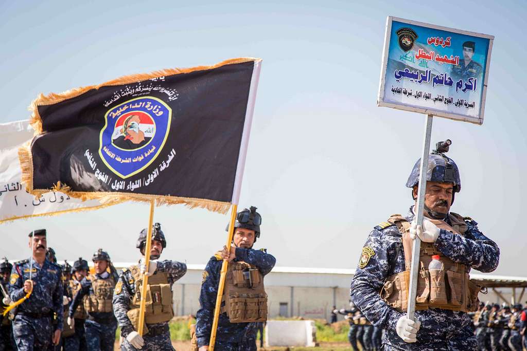Irakische Polizisten halten während einer Polizeiaktion die Flagge