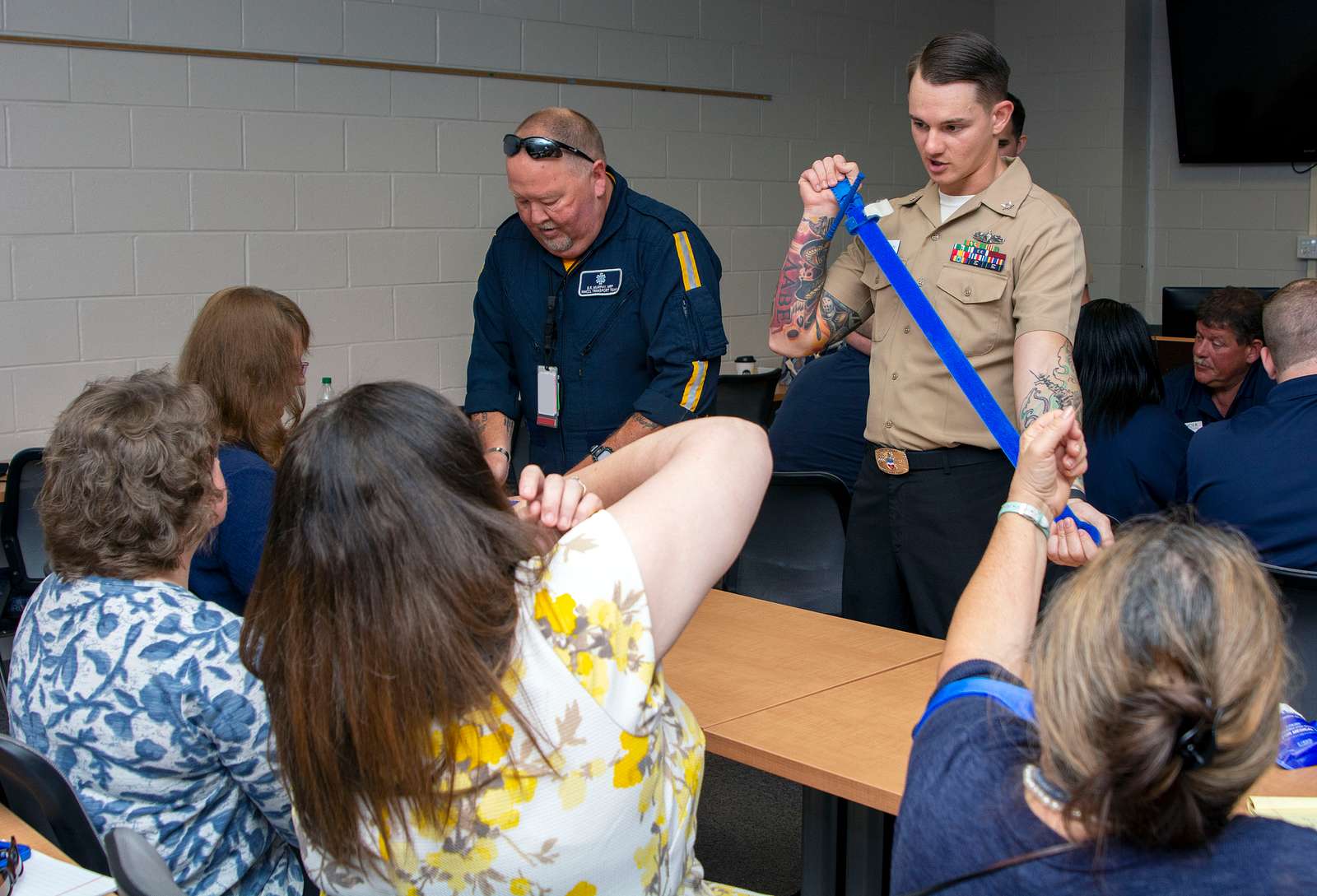 Col. Thomas Brittain, left, cuts the ribbon with a sword with help from  Command Sgt. Major Matthew Barnes, center, and Specialist Stafford Smith  during the Ribbon Cutting Ceremony at the remodel Lewis