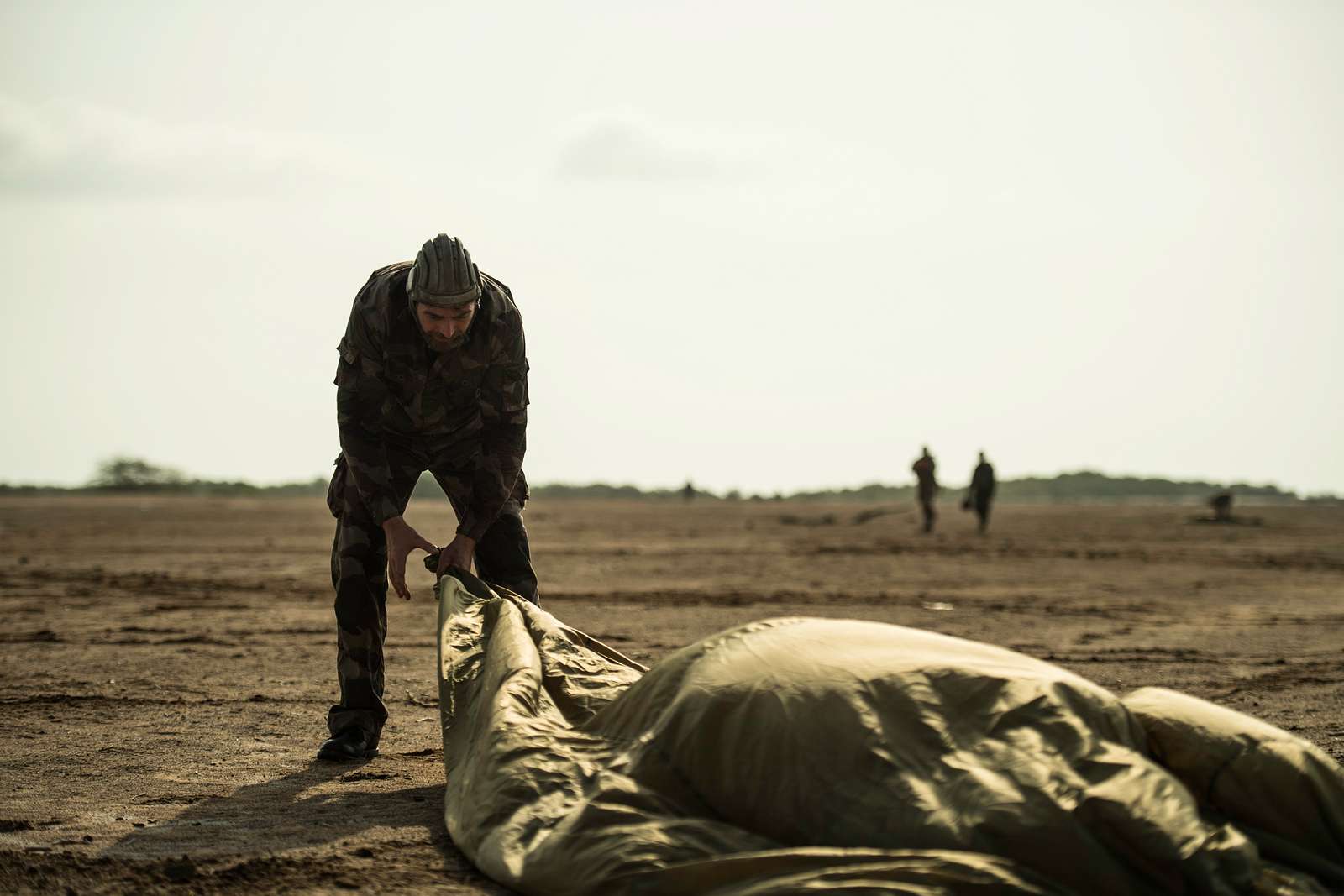 A French paratrooper collects his parachute after performing - NARA ...