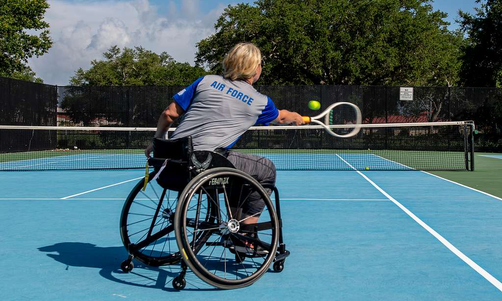 Woman using a wheelchair plays tennis 