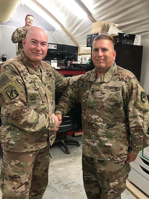 Chief Warrant Officer 2 Titus Sanders, a Steelers fan and pilot deployed to  Iraq with the Enhanced Combat Aviation Brigade, 1st Infantry Division,  holds up a piece of Pittsburgh gear while watching