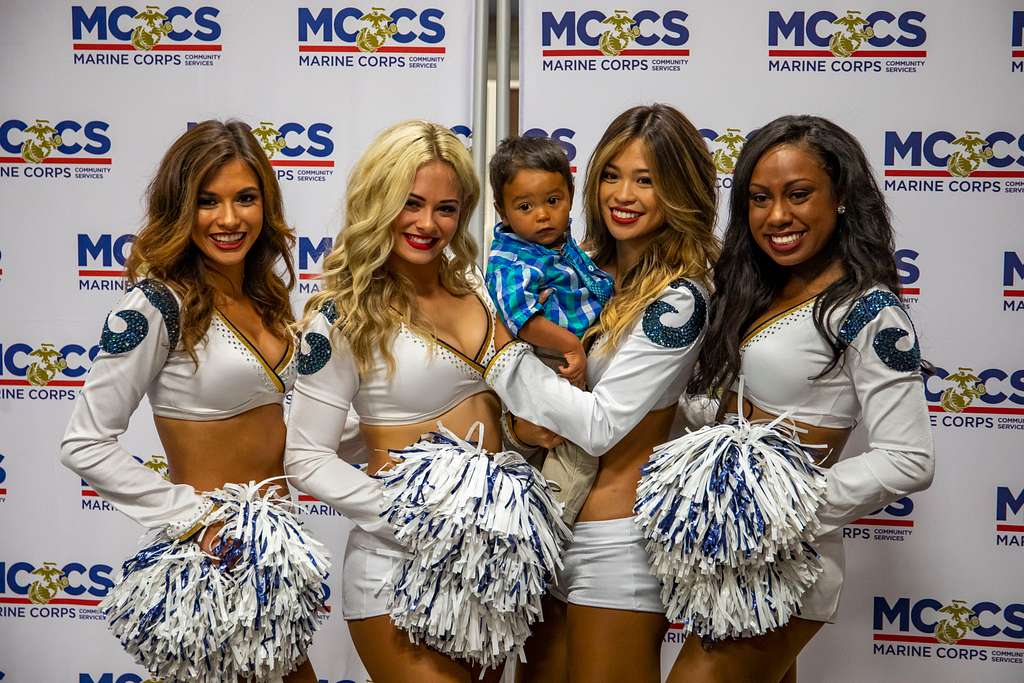 Los Angeles Rams cheerleaders pose with a child during - PICRYL