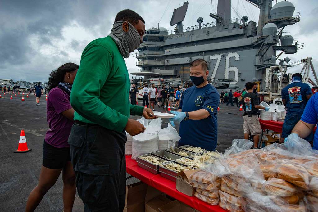 Sailors serve food during a steel beach picnic on the - PICRYL