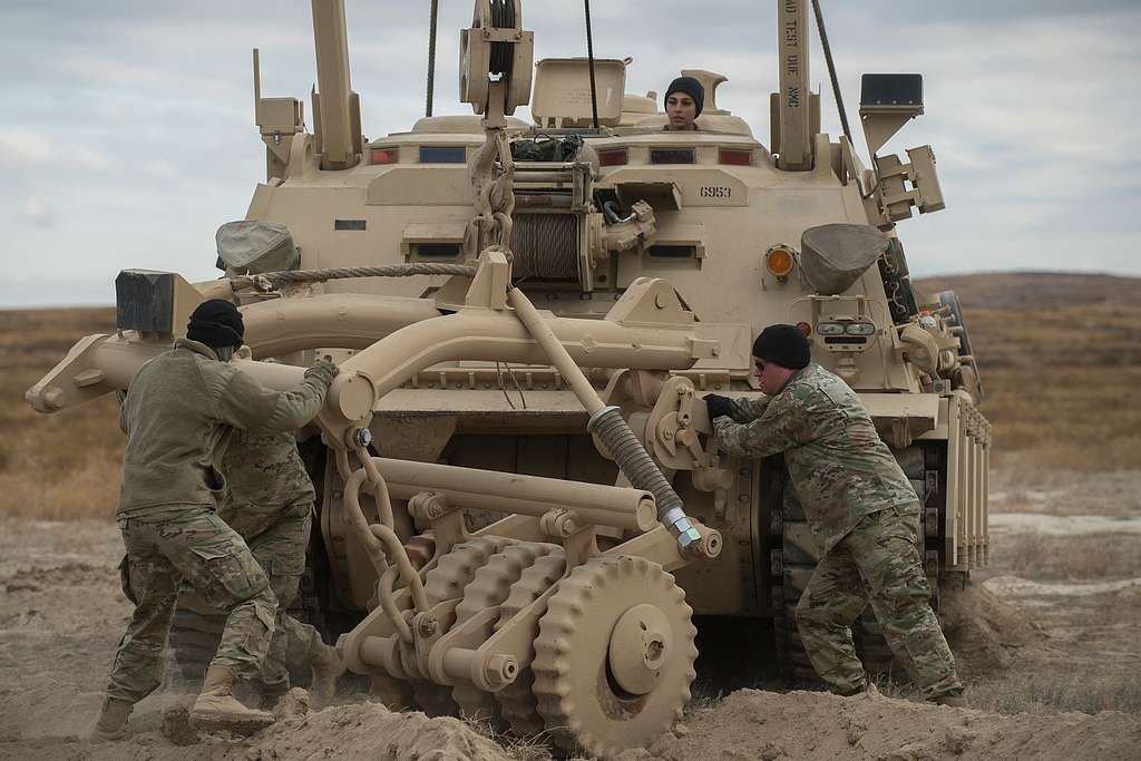 Soldiers wrestle a set of mine rollers in a better - NARA & DVIDS ...