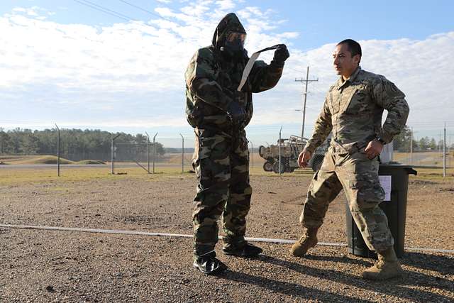 Two Soldiers from Task Force 3330, 3rd Special Forces Group (Airborne),  teach a class on how to properly remove MOPP (Mission-Oriented Protective  Posture) gear in the event of a simulated CBRN (Chemical