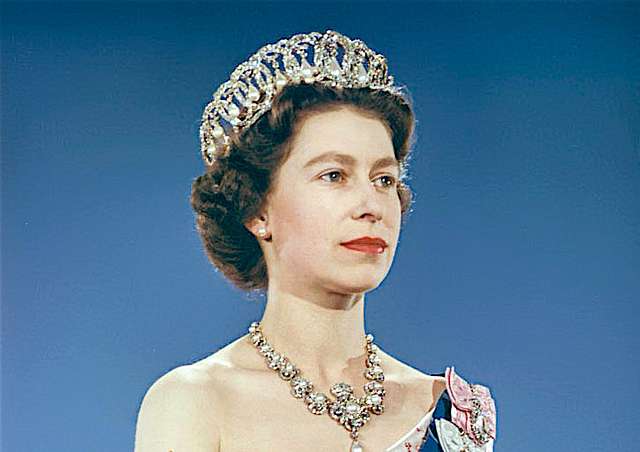 Queen Elizabeth II wearing crown, blue sash and pink gown …