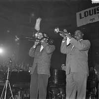 Louis Armstrong 1947 - A man in a blue suit playing a trumpet