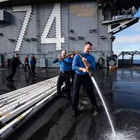 Offensive Tackle for the National Football League (NFL) San Diego Chargers,  Leander Jordan (75), signs an autograph for Aviation Electrician's Mate 3rd  Class Jerimy Holt during a visit aboard USS Ronald Reagan (