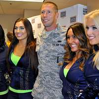 Los Angeles Rams cheerleaders pose with a child during - PICRYL