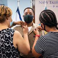 Offensive Tackle for the National Football League (NFL) San Diego Chargers,  Leander Jordan (75), signs an autograph for Aviation Electrician's Mate 3rd  Class Jerimy Holt during a visit aboard USS Ronald Reagan (