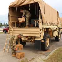 A crane is used to lift a canister containing a MIM-104 Patriot