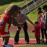 Clark, the Chicago Cubs mascot, signs a hat for a fan at the USO at USAG  Bavaria in Grafenwoehr, Germany, Dec. 11, 2018. The USO sponsored a Chicago  Cubs mascot tour of